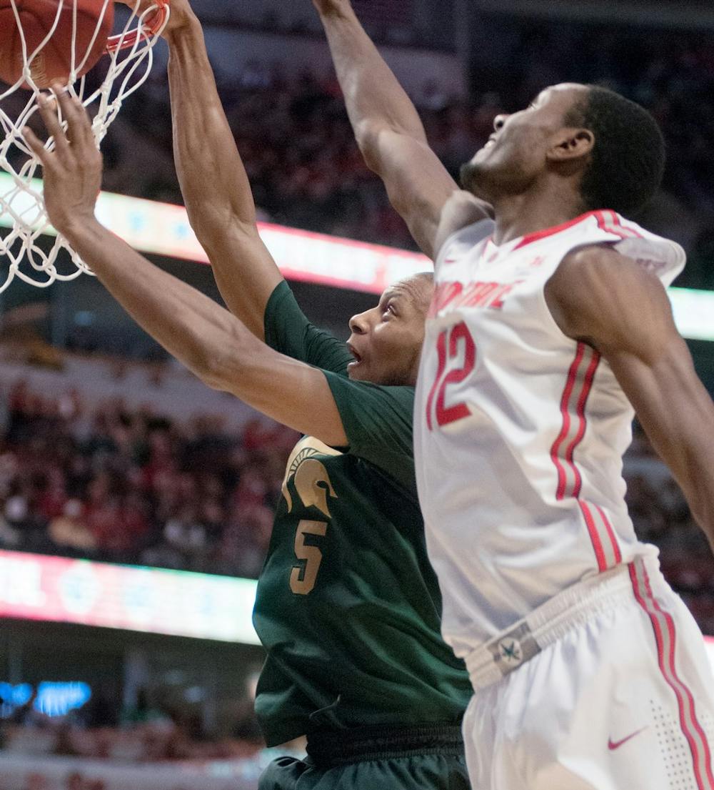 	<p>Junior forward Adreian Payne goes to dunk the ball as Ohio State&#8217;s forward Sam Thompson attempts to block during first half of the semifinal round of the Big Ten Tournament on March 16, 2013, at United Center in Chicago, Ill. The Spartans lead the Buckeyes 29-28. Natalie Kolb/The State News</p>