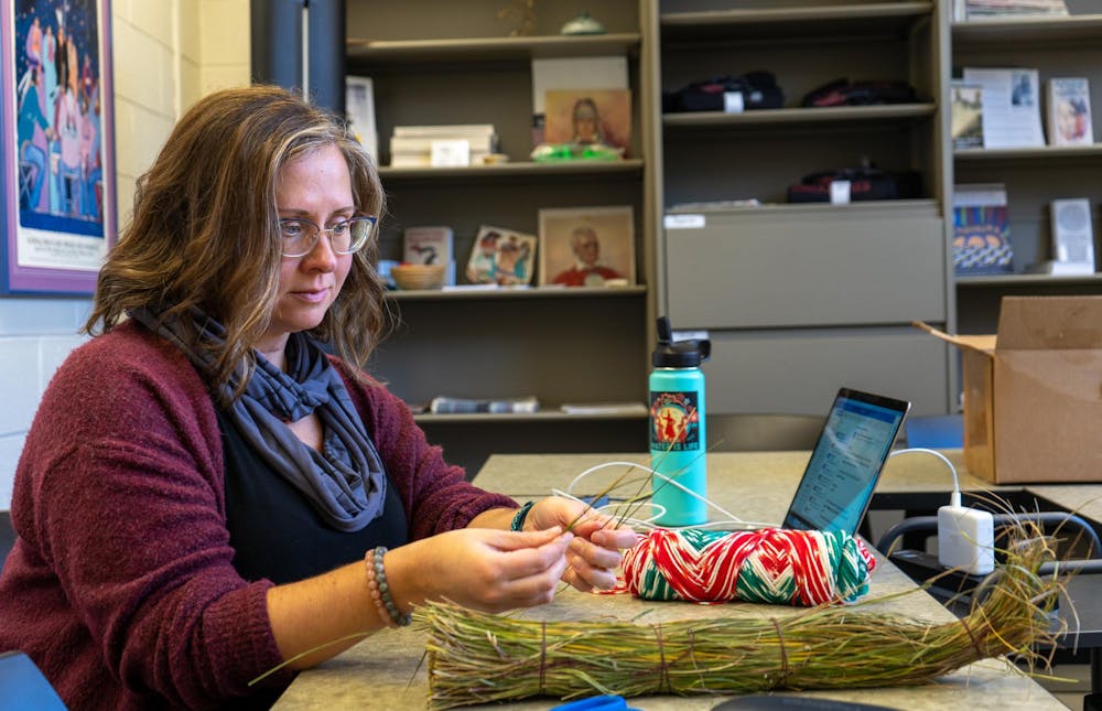 Writing, Rhetoric, and American Cultures associate professor Kristin Arola handles sweetgrass in the Urban Planning and Landscape Architecture building on Nov. 15, 2023