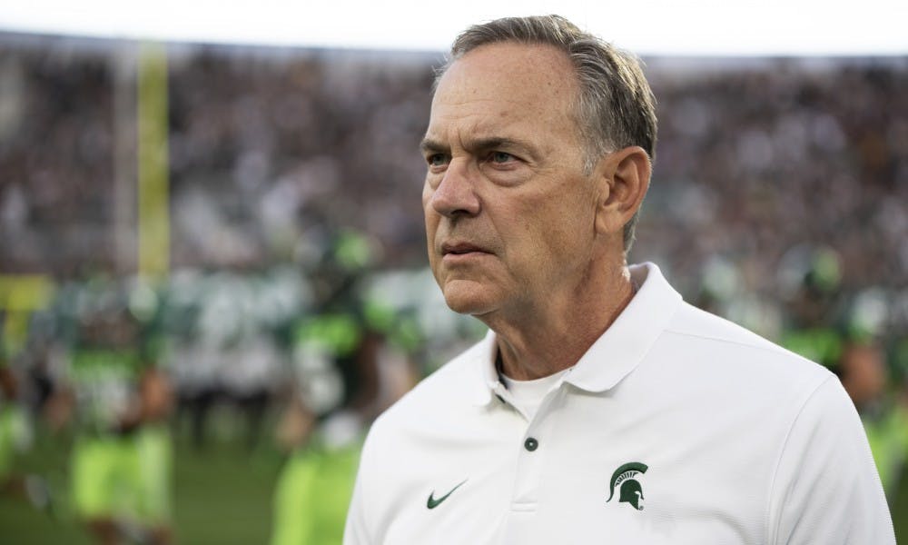 <p>Coach Mark Dantonio walks onto the field preparing for the game against the Broncos at Spartan Stadium on September 7, 2019.</p>