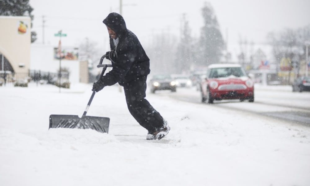 Lansing resident Ellington Fields shovels snow during a snow storm on March 1, 2016 on Grand River Ave.
