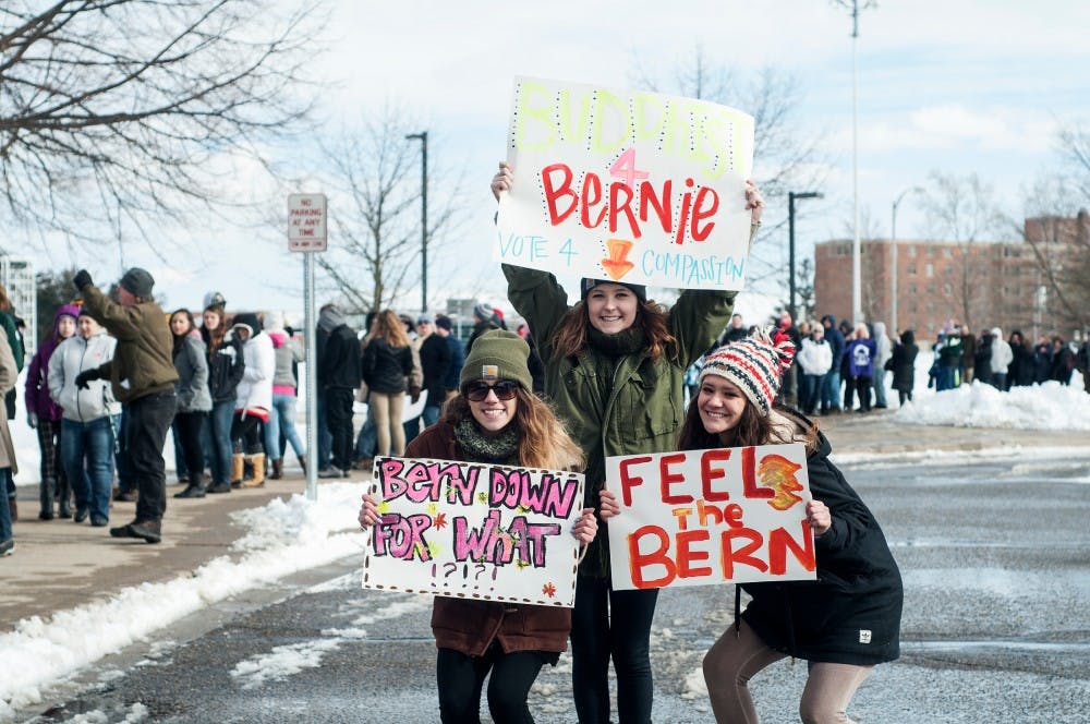 From left to right, Lansing Community College freshmen Andrea Beagan, Okemos High School senior Abigail Wilson, and LCC sophomore Naomi Beagan pose for a picture while holding signs on March 2, 2016 at Breslin Center.