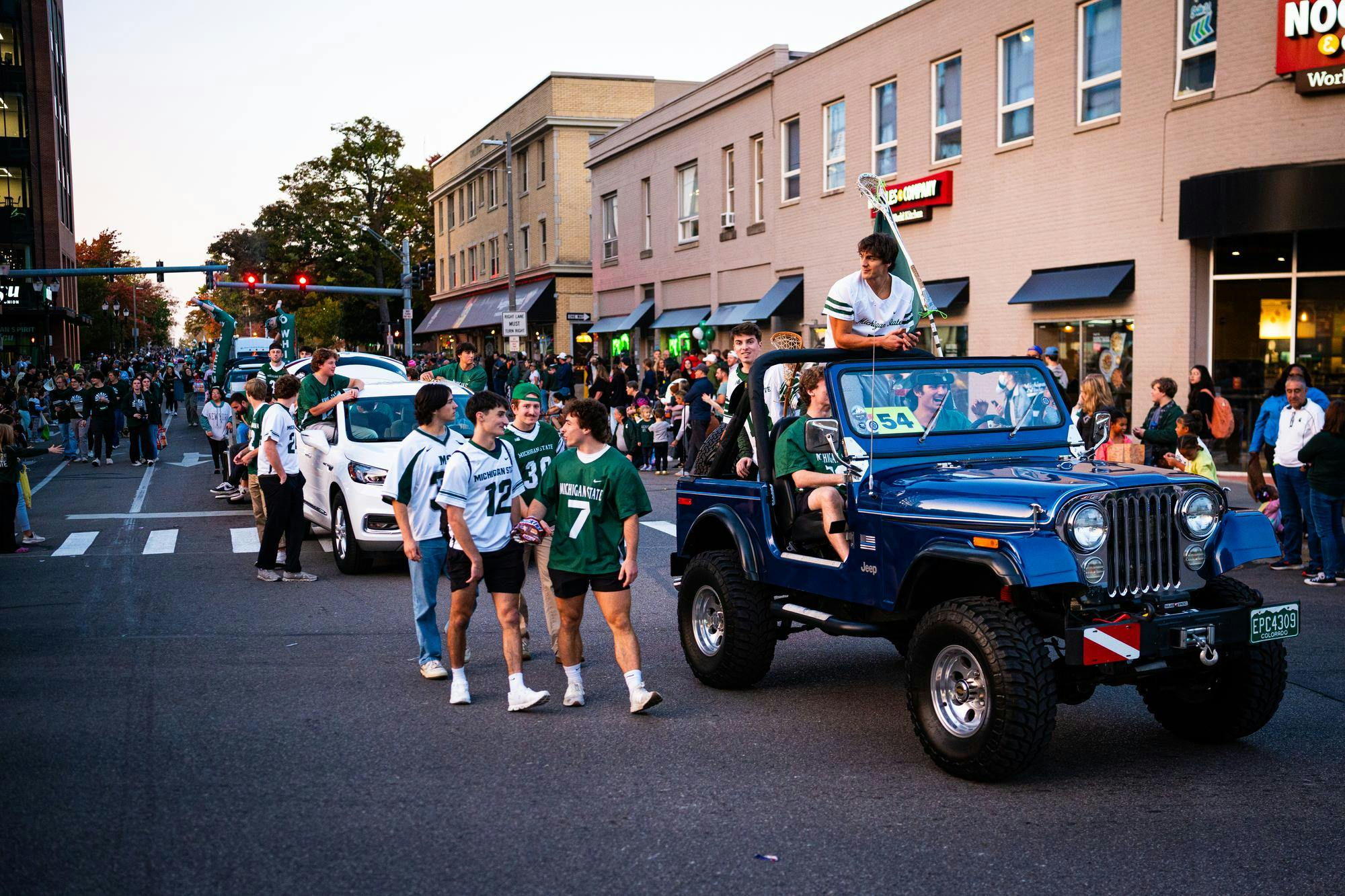 The Michigan State University (MSU) Men's Lacrosse Team crosses the intersection of Grand River Avenue and Abbot Road during the 2024 MSU Homecoming Parade on Oct. 18, 2024.