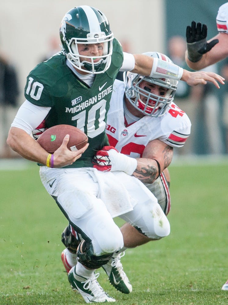 	<p>Junior quarterback Andrew Maxwell holds onto the ball as he is being taken down by Ohio State full back Zach Boren. The Buckeyes defeated the Spartans, 17-16, on Saturday, Sept. 29, 2012 at Spartan Stadium. Justin Wan/The State News</p>