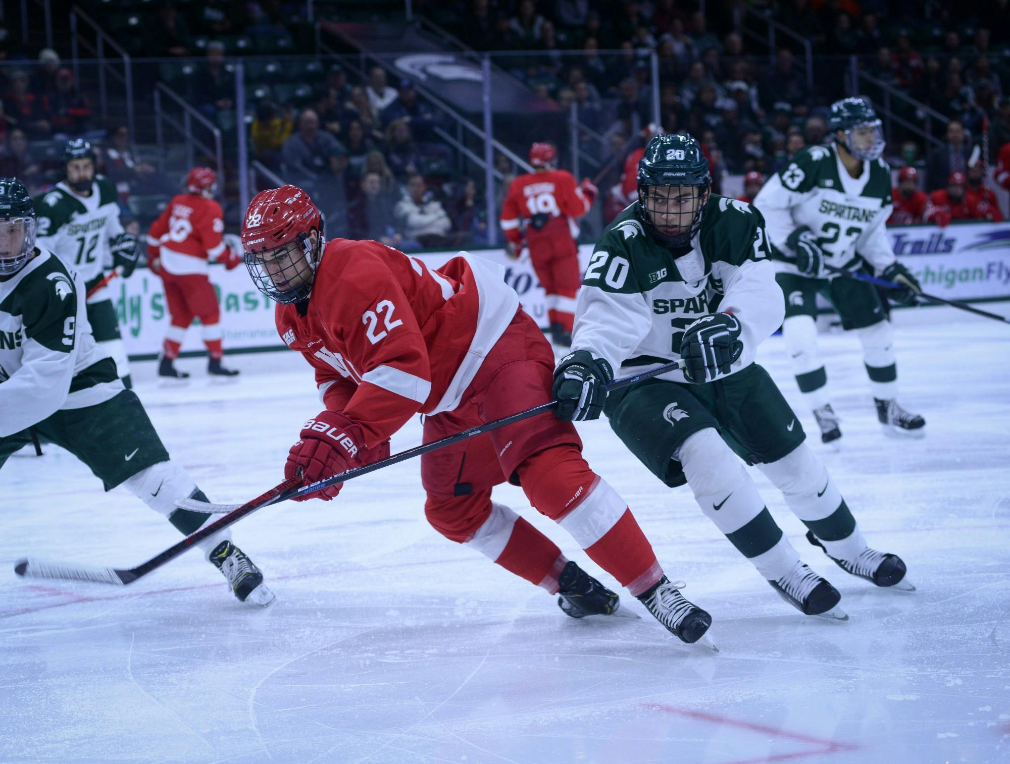 Freshman forward Josh Nodler (20) fights for the puck during the game against Cornell at Munn Ice Arena on Nov. 2, 2019. The Spartans lost to the Big Red, 6-2.