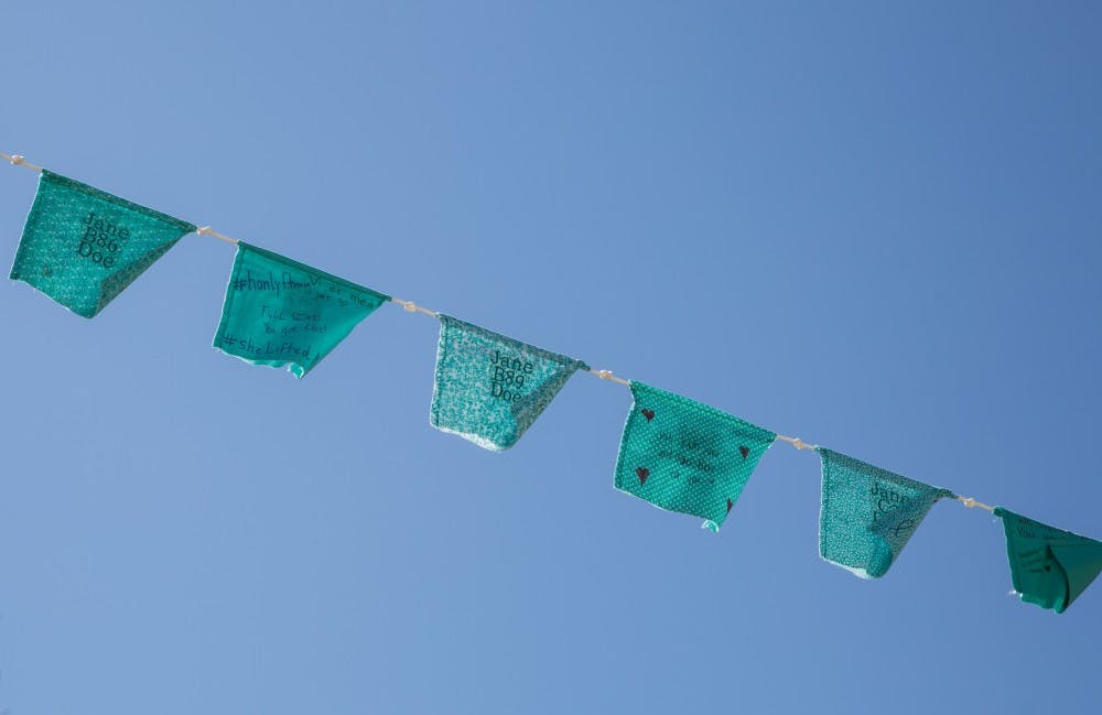 <p>Teal flags are displayed along Grand River Avenue on April 3, 2019.</p>