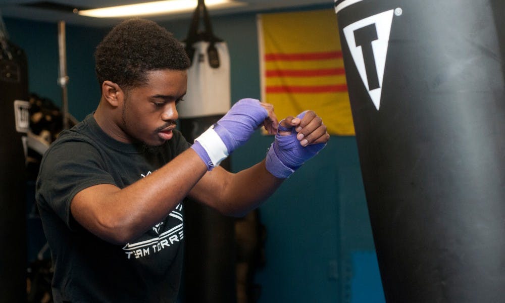 <p>Animal science junior Evan Carter-Taylor practices hitting on a punching bag on Nov. 6, 2015 at East Lansing Underground Martial Arts, 541 E Grand River Ave, in East Lansing. Carter-Taylor has been kick-boxing and MMA fighting since high school and still finds time to enjoy the sport despite his schedule as a student. </p>