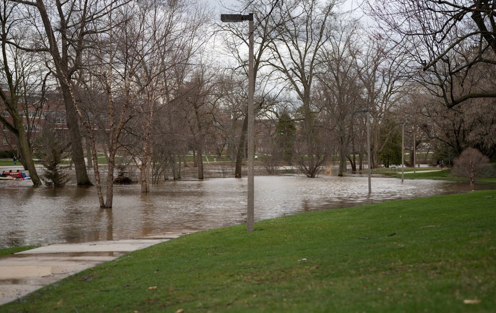 The Red Cedar River floods the sidewalk after heavy rainfall on campus on April 5, 2023.