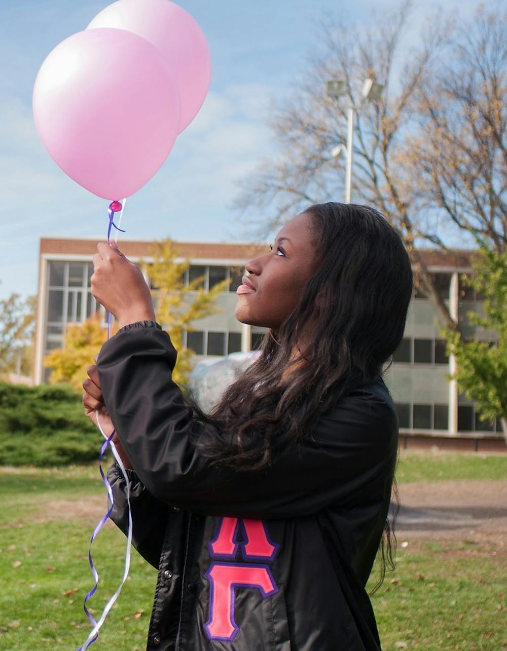 	<p>Psychology senior Titi Oladipo holds pink balloons on Oct. 27, 2013, at the rock on Farm Lane. The West Michigan Association of Sigma Lambda Gamma released 45 pink balloons with messages for Breast Cancer Awareness Month. Georgina De Moya/The State News</p>