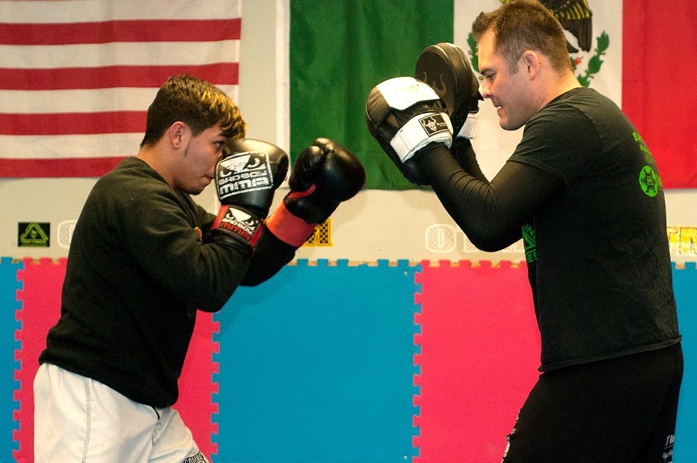 	<p>Matt Torres, right, head trainer at East Lansing Underground <span class="caps">MMA</span>, trains Lansing resident Angel Reyes, on Jan. 22, 2014, at the school, 541 E. Grand River Ave. The gym has a success rate of over 85 percent in fights. </p>