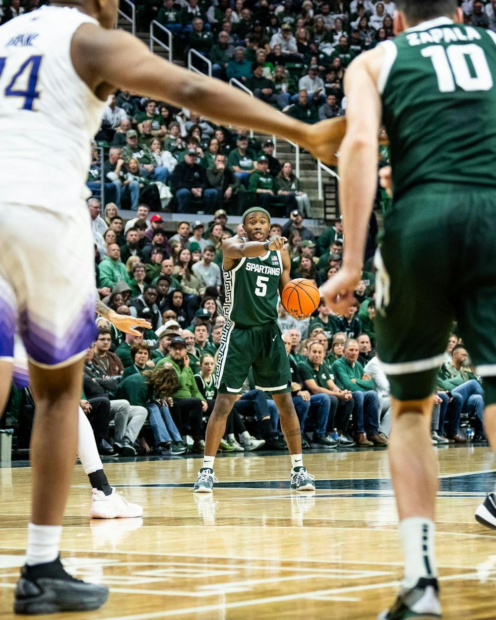 Michigan State junior guard Tre Holloman (5) directs his teammates during a game against the University of Washington at the Breslin Center in East Lansing, Michigan on January 9, 2025. Michigan State won 88-54. 