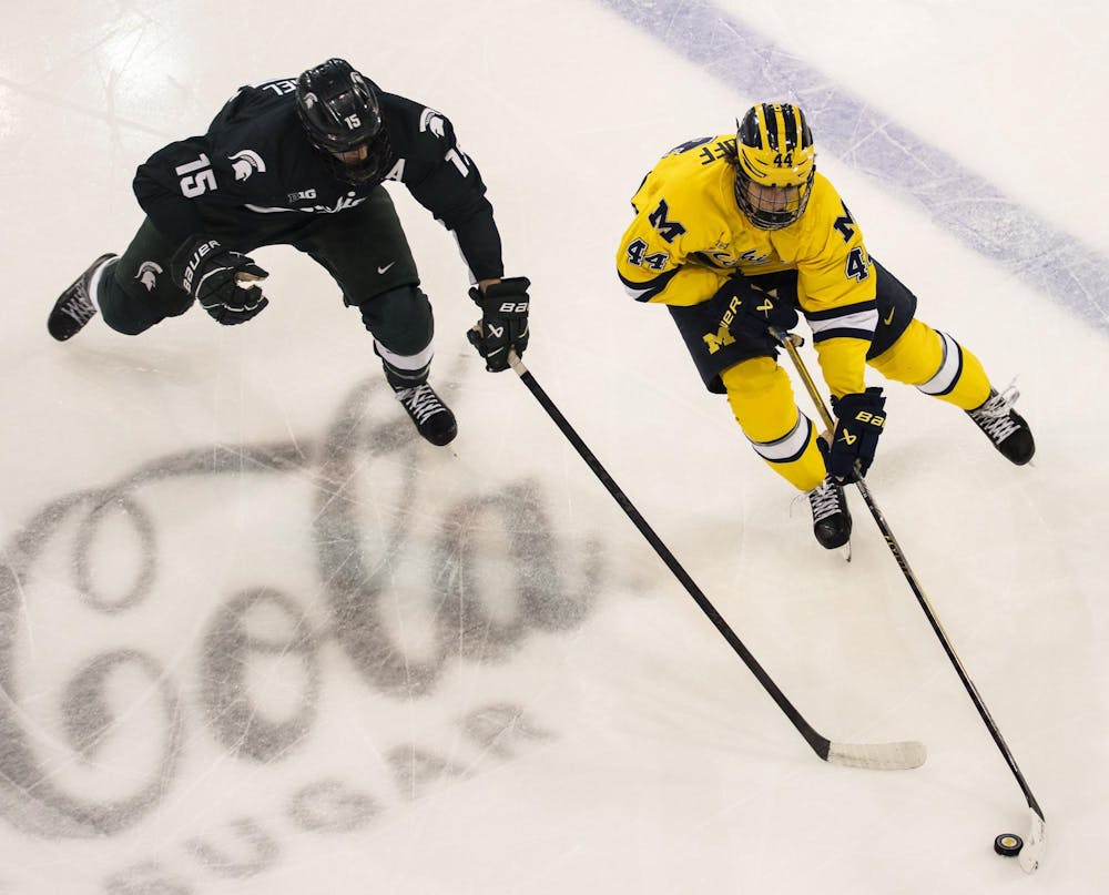 <p>University of Michigan sophomore forward Will Horcoff (44) takes the puck as Michigan State senior forward Charlie Stramel (15) skates after him at the Yost Ice Arena in Ann Arbor, Mich. on Dec. 6, 2025.</p>