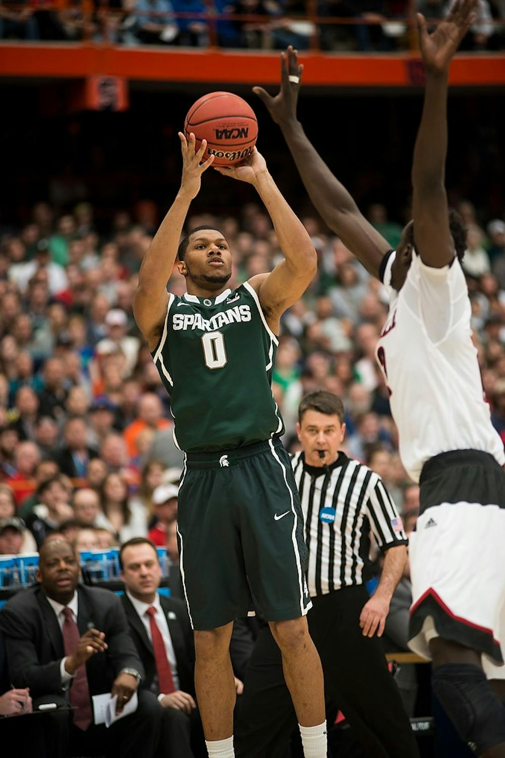 <p>Freshman forward Marvin Clark Jr. attempts a point over Louisville forward/center Mangok Mathiang March 29, 2015, during the East Regional round of the NCAA Tournament in the Elite Eight against Louisville at the Carrier Dome in Syracuse, New York. At halftime, the Spartans were lead by the cardinals, 40-32. Erin Hampton/The State News</p>