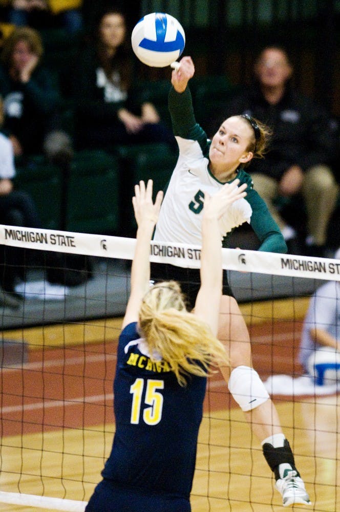 Senior outside hitter Jenilee Rathje hits the ball over Michigan middle blocker Courtney Fletcher Wednesday at Jenison Field House. The Spartans defeated the Wolverines 3-1. Matt Radick/The State News