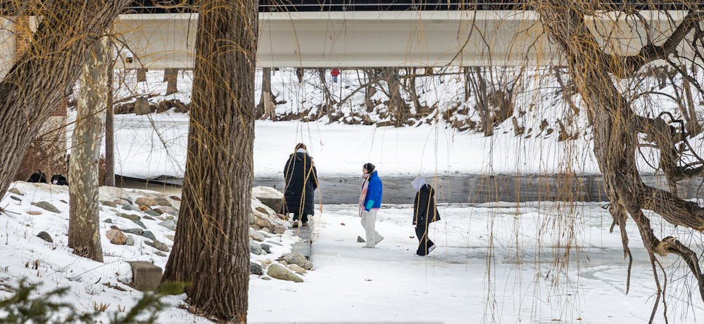 MSU students cross the over the frozen Red Cedar River in East Lansing, MI on Feb. 11, 2206.