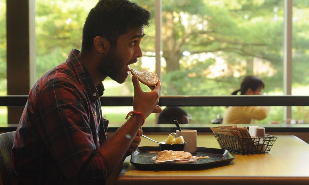 <p>Mechanical engineering senior Yash Kankaria eats a bagel on Sept. 20, 2015, inside the cafeteria in Case Hall. Kankaria has morning classes and usually eats breakfast before classes. &quot;It&#x27;s really crowded here, so it does get a bit frantic,&quot; Kankaria said.</p>