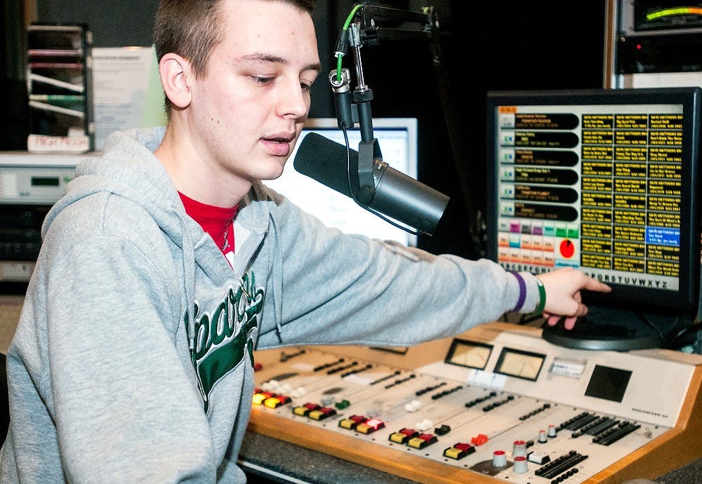 	<p>Journalism sophomore Aaron Jordan cues up the next song while working as the DJ for Impact 89FM on Wednesday in Holden Hall. The station will not be receiving $300,000 in already-collected student taxes from the 2012-2013 academic year. The funds will be returned to the students. Adam Toolin/The State News</p>