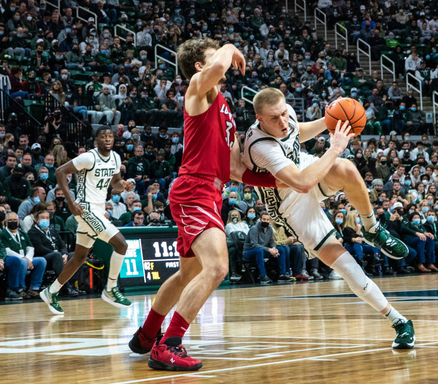 <p>Redshirt senior forward Joey Hauser (10) avoids a deflection from a Louisville player during the first half. The Spartans beat the Cardinals, 73-64, to win the B1G/ACC Challenge on Dec. 1, 2021. </p>