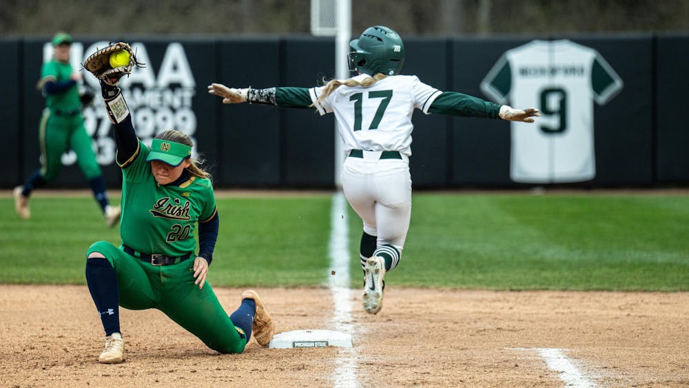 MSU freshman outfielder Ava Coffinger (17) touches the first base while Notre Dame freshman infielder Kaia Cortes (20) catches the ball at MSU  Secchia Stadium on April 15, 2025.