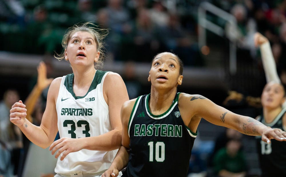 Michigan State University freshman forward Juliann Woodard (33) and Eastern Michigan University graduate student ZaNiya Nelson (10) look to catch the rebound during their game at the Breslin Center on Nov. 11, 2024. The Spartans secured the win, 95-49, against the Eagles.