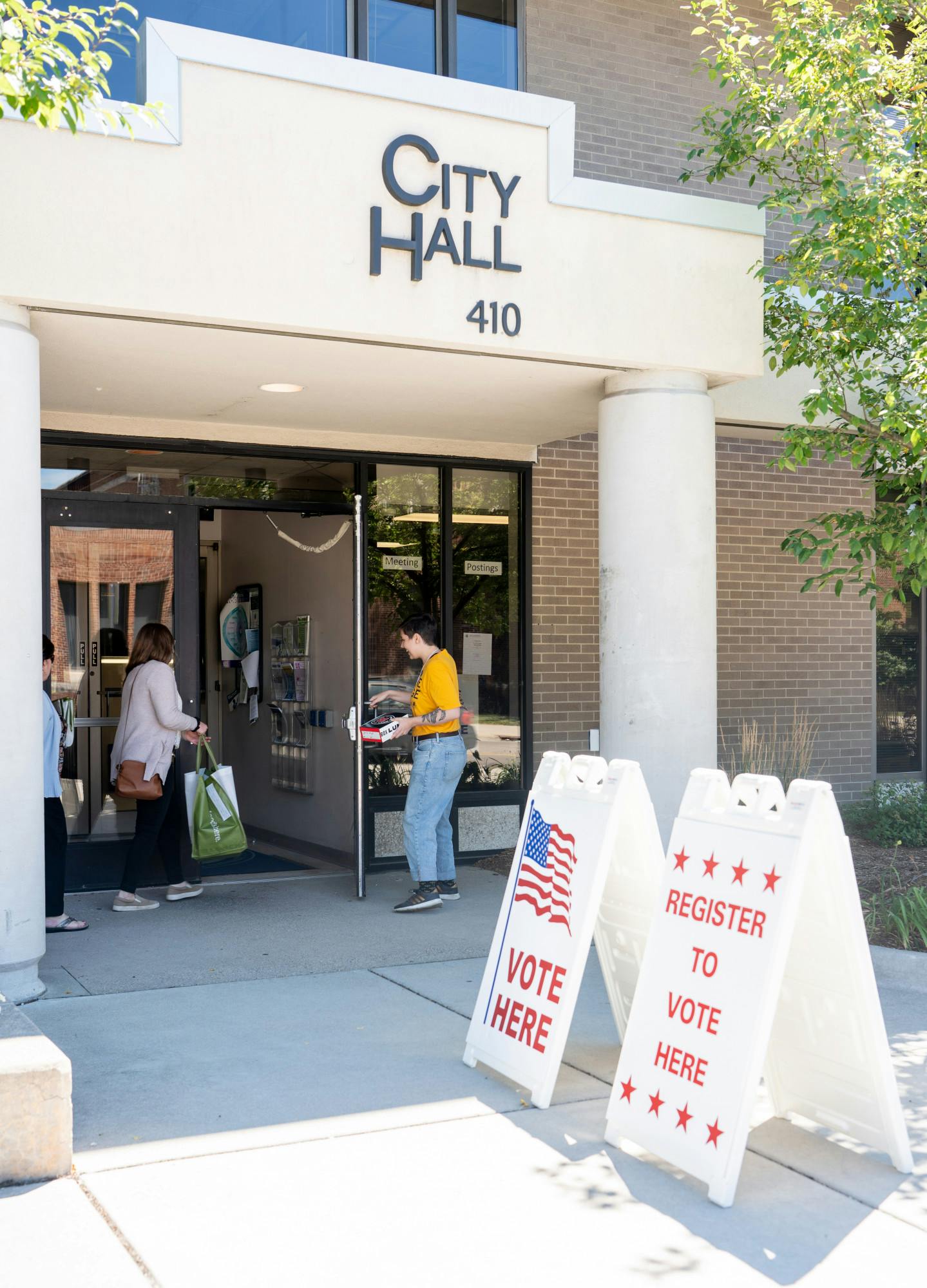 <p>People enter East Lansing City Hall on Aug. 2, 2022, voting day for the Michigan primary elections.</p>