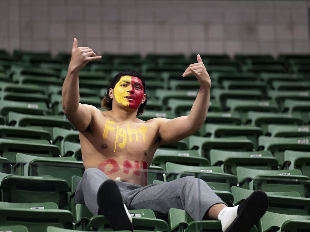 A USC fan with face paint and “Fight On!” written across his chest gestures toward the court during the volleyball game against USC at the Breslin Center on Wednesday, Nov. 26, 2025.
