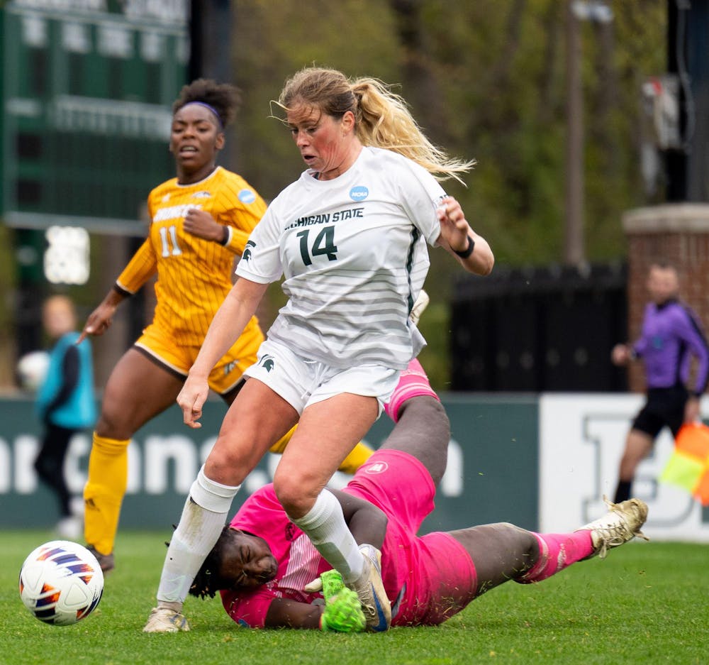 Michigan State University graduate forward Mackenzie Anthony (14) moves past Western Michigan University senior goalkeeper Lauren Boafo (00) during the NCAA soccer tournament between MSU and WMU on Nov. 16, 2024. The Spartans defeated the Broncos, 3-1.