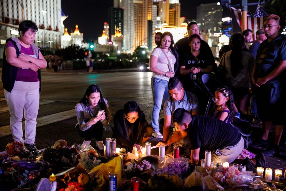 People visit and pay their respects at a makeshift memorial for the victims of the recent mass shooting on Reno Ave and Las Vegas Blvd. on Oct. 3, 2017 in Las Vegas. Photo by Marcus Yam / Los Angeles Times/TNS.