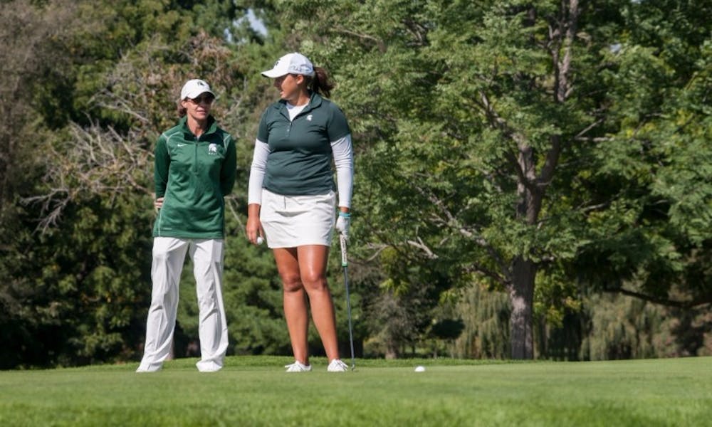 <p>Women's golf head coach Stacy Slobodnik, left, talks with redshirt-junior Katie Sharp before a putt on Sept. 25, 2016 at Forest Akers West Golf Course. Slobodnik has held the head coaching position at MSU for 19 years.</p>