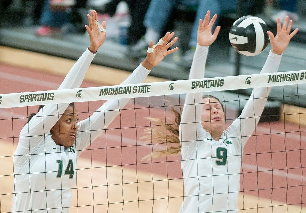 Sophomore middle blocker and outside hitter Jazmine White, left, and sophomore setter Taylor Galloway, right, attempt to block the ball during the game against Ohio State on Saturday at Jenison Field House. MSU lost the game 3-1. Danyelle Morrow/The State News