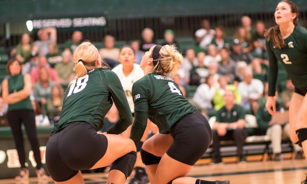 Freshman defensive specialist Jamye Cox (4) and senior outside hitter Holly Tolliver (18) go after a ball during the game against Corpus Christi. The Spartans defeated the Islanders, 3-0.