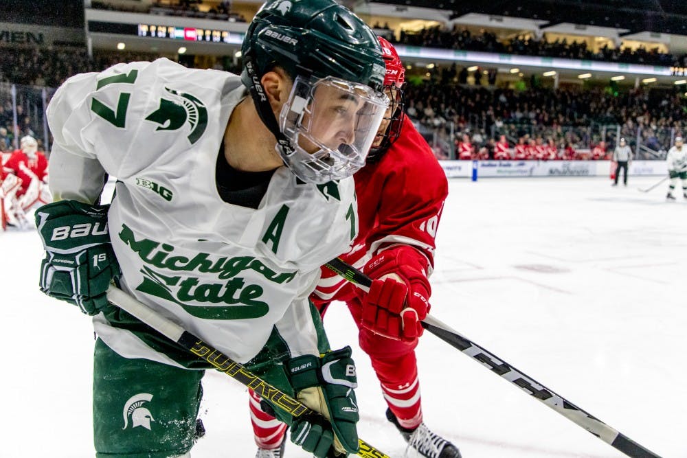 Junior wing Taro Hirose (17) pins the puck against the boards during the game against Wisconsin on Feb. 2, 2019. The Spartans trail the Badgers 1-0 at the end of the first period.