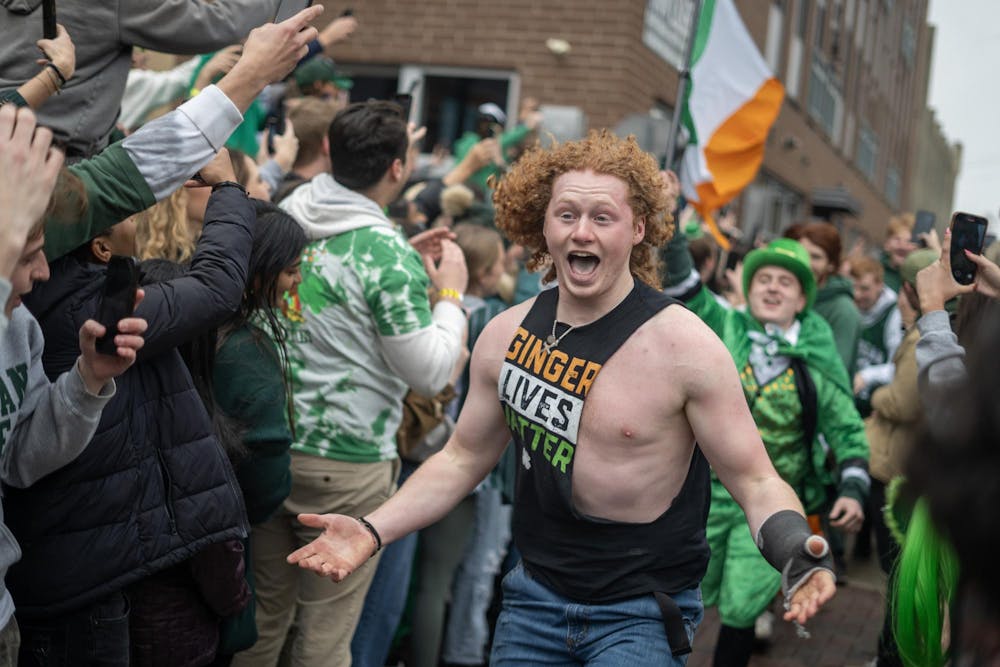 <p>A participant of the ginger run races through the celebratory St. Patrick’s Day crowd on Grand River on March 17, 2024.&nbsp;</p>