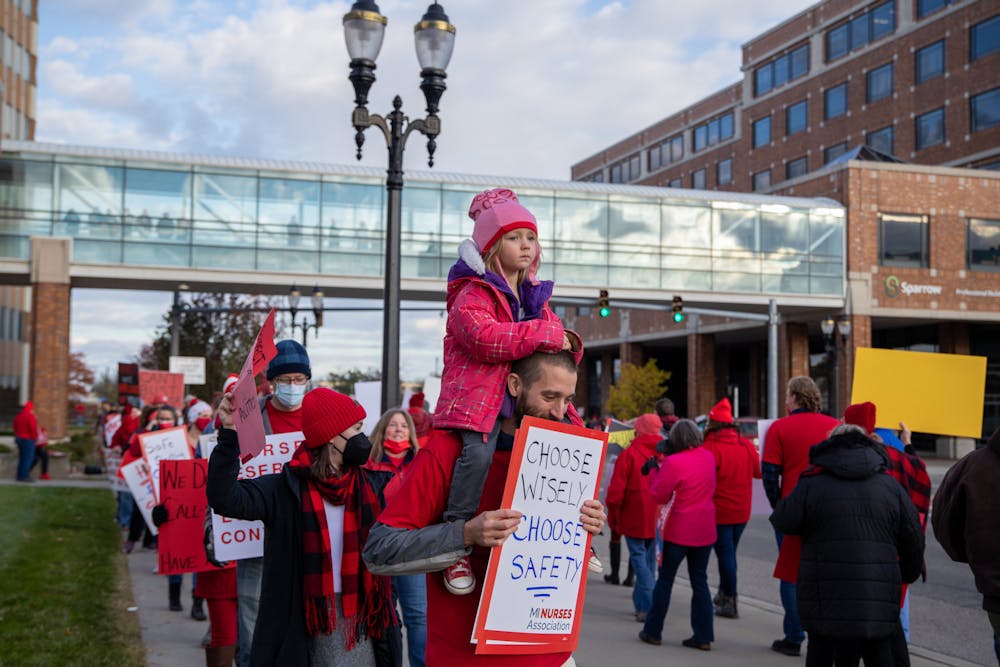 <p>Sparrow nurses, along with supporters of them, picket along Michigan Avenue in Lansing on Nov. 3, 2021. </p>