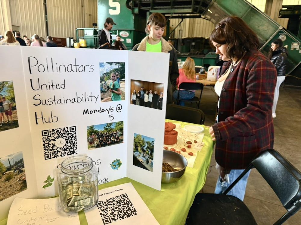 <p>Attendees at look at the various tables and activities at the MSU Earth Bash at the Surplus Store on April 12, 2025.</p>