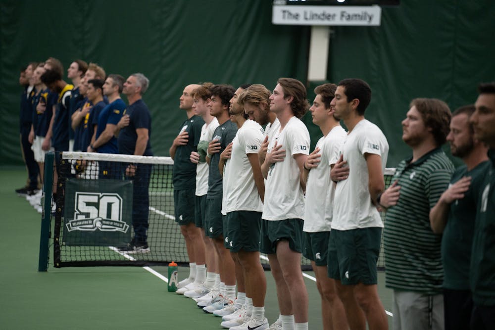 <p>The MSU men's tennis team stands for the national anthem before their match against Michigan at the MSU Tennis Center on March 30, 2023. The Spartans lost to the Wolverines 6-1.</p>
