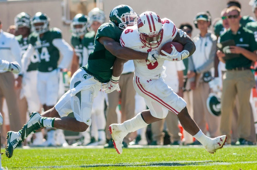 Senior defensive back Demetrius Cox (7) tackled Wisconsin running back Corey Clement (6) during the game against Wisconsin on Sept. 24, 2016 at Spartan Stadium. The Spartans were defeated by the Badgers, 30-6.