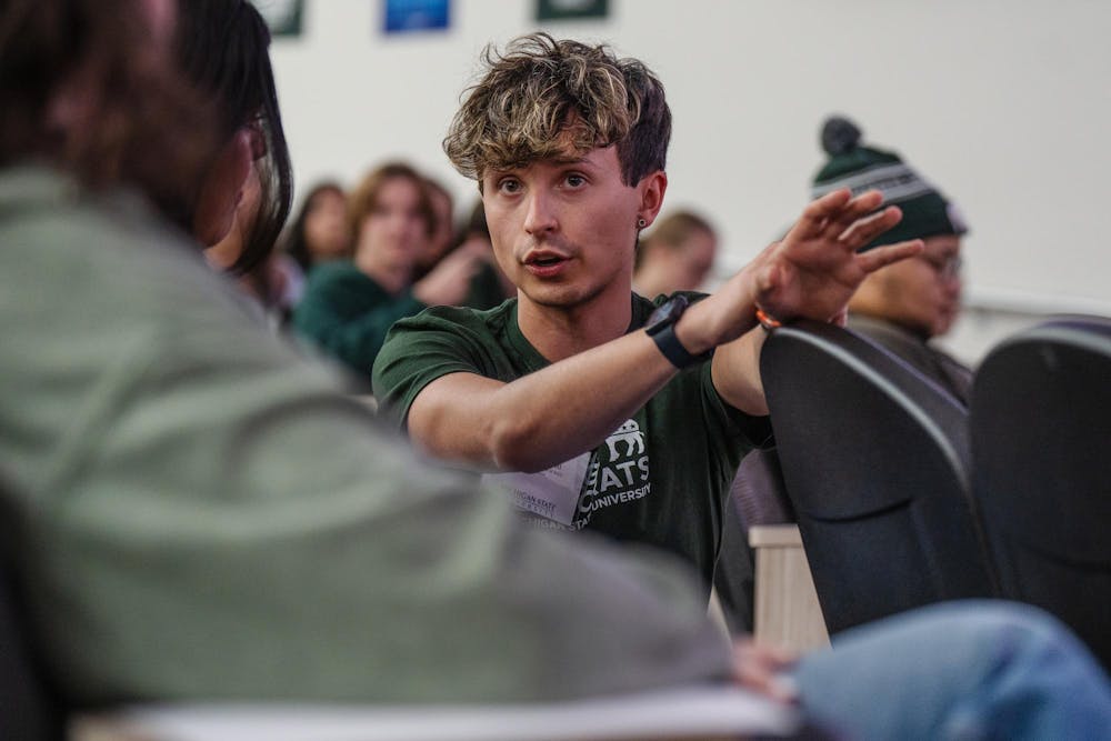 Political theory and constitutional democracy senior and president of the College Democrats at MSU Liam Richichi chats with members of the organization before the guest speaker arrives. Michigan Gov. Gretchen Whitmer spoke to the college democrats at the Vet Med building on Oct. 8, 2024. 