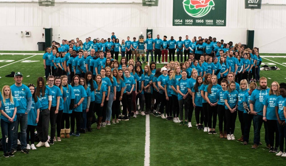 <p>Students and the community wear teal and form a human teal ribbon at the It's On Us Day of Action event at Duffy Daugherty Foottball Stadium on April 6, 2018. (Annie Barker | State News)</p>