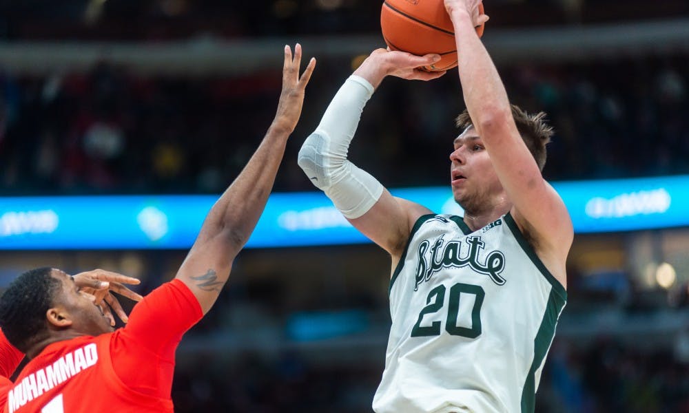 <p>Senior guard Matt McQuaid (20) shoots the ball against Ohio State. The Spartans beat the Buckeyes, 77-70 at the United Center on March 15, 2019.</p>