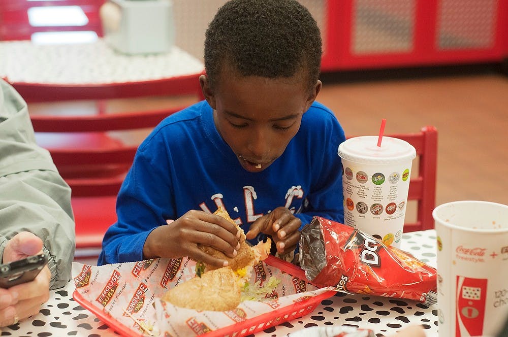 <p>Bloomington, Ill. resident Elias Komnick, 7, eats a sub Oct. 13, 2014, at Firehouse Subs, 245 Ann Street, in East Lansing. Komnick was stopping for lunch with his family who were going on college visits. Jessalyn Tamez/The State News</p>