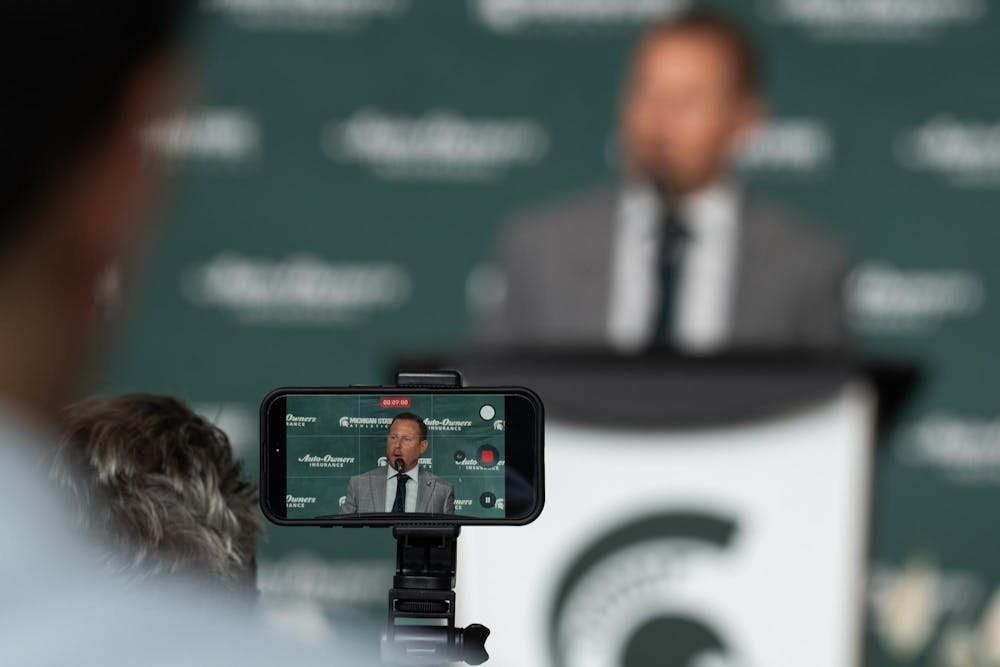 <p>Michigan State University's new vice president and athletic director, Dan Bartholomae, speaks at a press conference introducing him to the community as someone records with their cellphone at the Breslin Center in East Lansing, Mich., on Aug. 19, 2026.</p>
