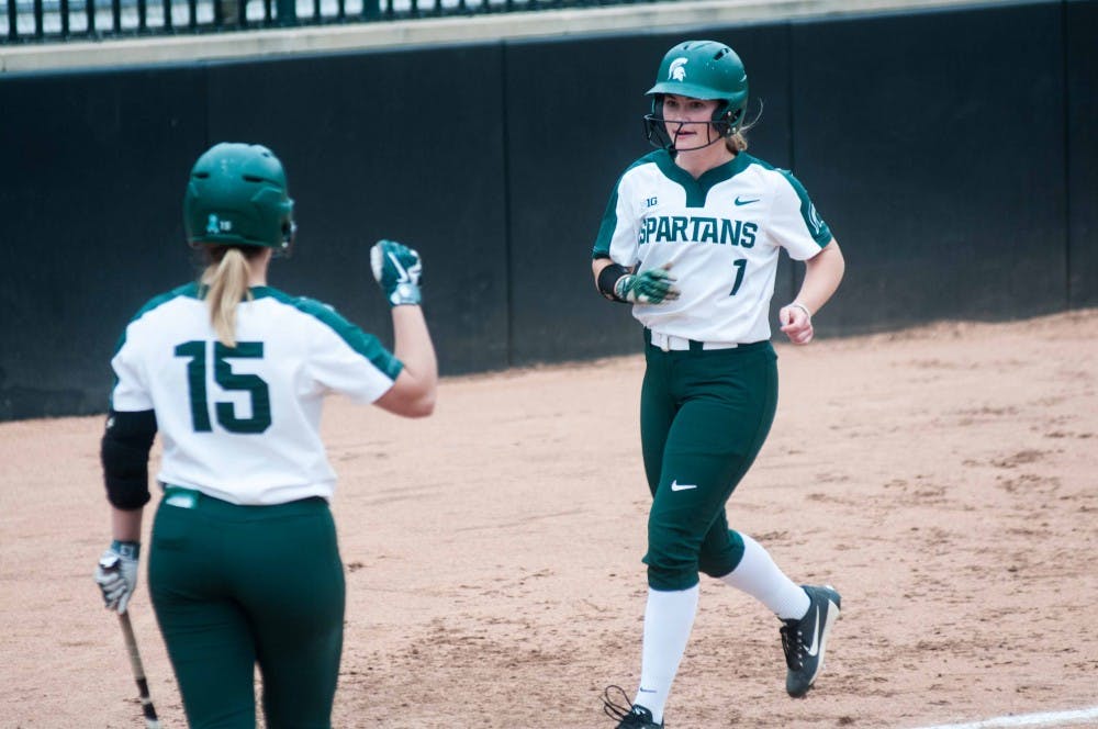 Junior outfielder Lexi White (15) cheers for senior outfielder Lea Foerster (1) during the game against Eastern Michigan on April 24, 2018 at Secchia Stadium. The Spartans defeated the Eagles, 9-1 in five innings. (Annie Barker | State News)