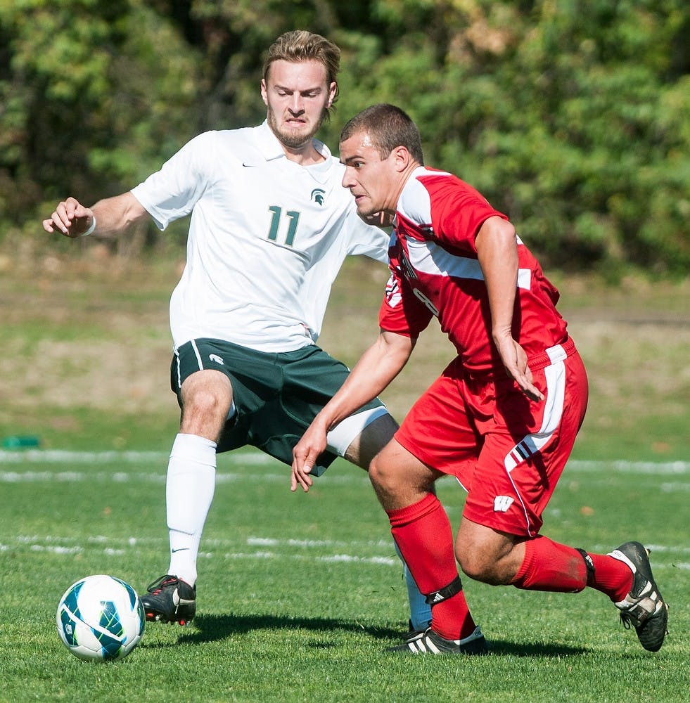 Sophomore defenseman Ryan Keener and Wisconsin defenseman Blake Succa jockey for possession of the ball during a game Oct. 21, 2012, at DeMartin Stadium at Old College Field. The Spartans won 2-0, causing the Badgers to fall to 5-7-3, 1-3-0 Big Ten. Julia Nagy/The State News