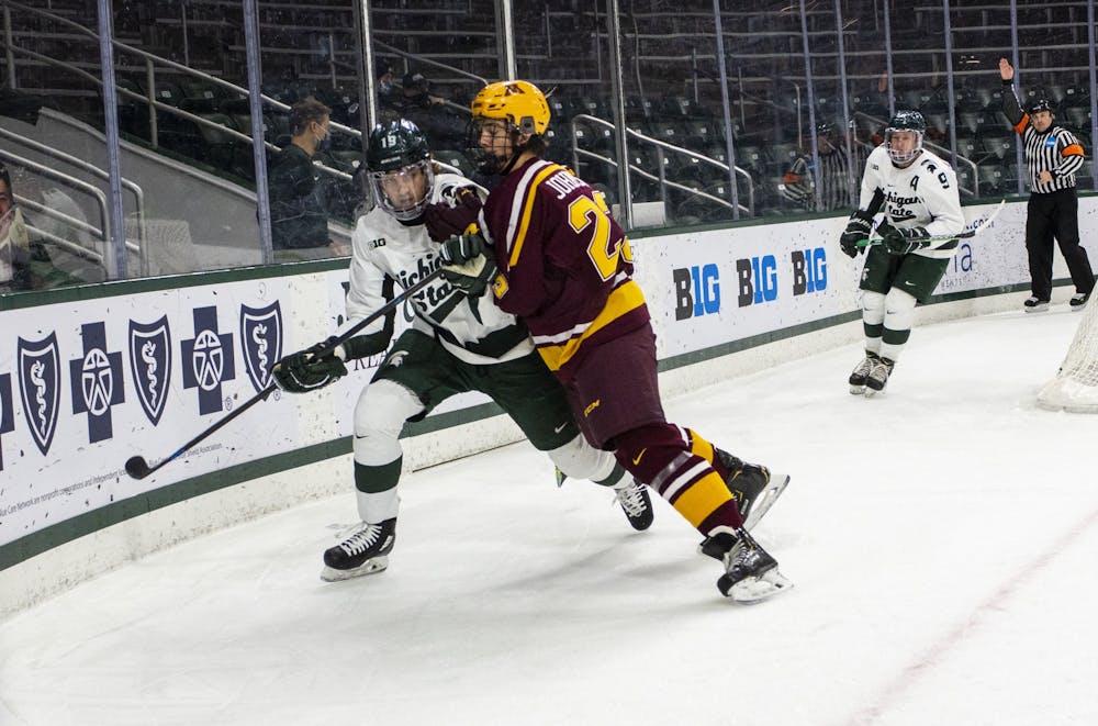 <p>Sophomore forward Nicolas Müller (19) attempted to gain possession of the puck to score on Minnesota. The Spartans fell to the Golden Gophers, 3-1, on Dec. 3, 2020.</p>