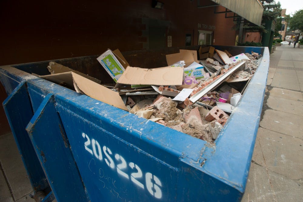 Debris sits in a dumpster on Sept. 21, 2016 outside of The State News. The debris is a result of the renovations that are ongoing underneath The State News.