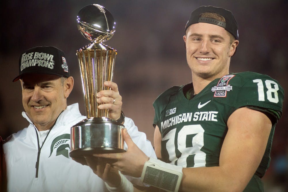 	<p>Sophomore quarterback Connor Cook and head coach Mark Dantonio hold the trophy after the 100th Rose Bowl game against Stanford on Jan. 1, 2014, in Pasadena, Calif. The Spartans defeated the Cardinal, 24-20. Julia Nagy/The State News</p>