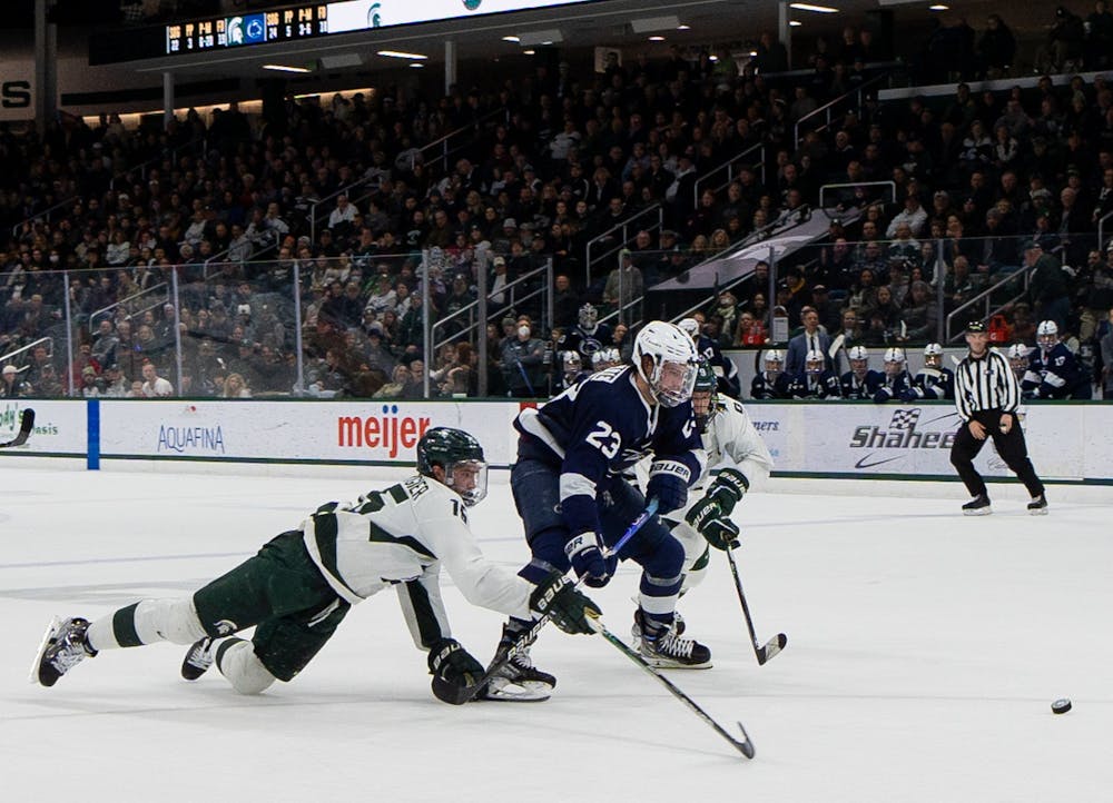 5th year defenseman Christian Krygier dives to defend the puck during a game against Penn State University at Munn Ice Arena on Jan. 13, 2023. The Spartans defeated the Nittany Lions with a score of 3-2. 