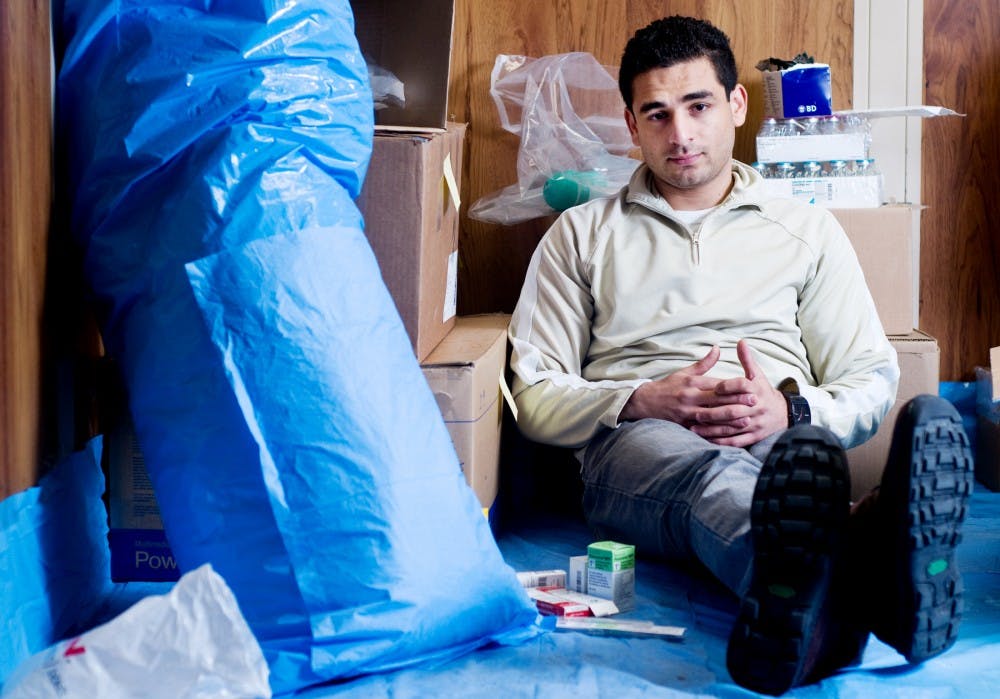 Biomedical engineering junior Raeuf Roushangar sits surrounded by medical supplies gathered by himself and other members of Generate Help to Help Generations. Roushangar is the founder and president of the group, which aims to collect medical supplies to send to countries in need around the globe. Matt Radick/The State News