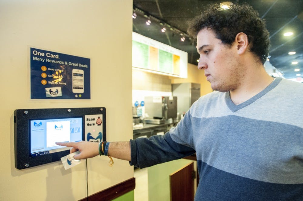 Recent MSU graduate Sam Appel acticates his FlockTAG loyalty card on Thursday afternoon, Sept. 20, 2012 at Bubble Island, of 515 E. Grand River Ave. The card can be used in multiple business aross East Lansing with to collect points and rewards all within one card. Justin Wan/The State News