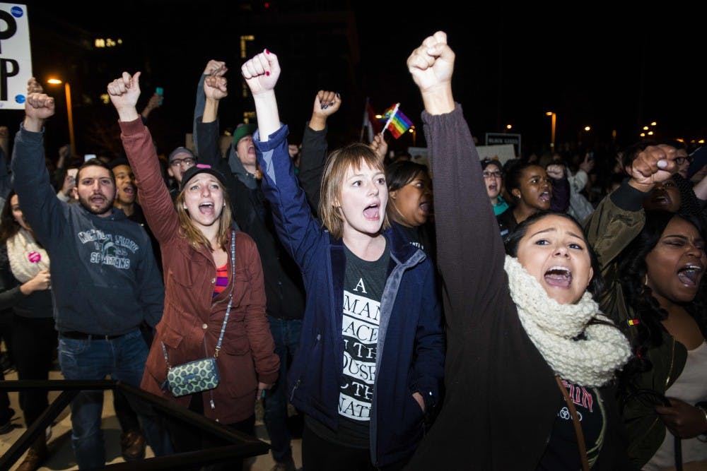 Students chant and raise their fists in the air on Nov. 10, 2016 outside of Hannah Administration Building. Thousands of students gathered together to unite and support one another.
